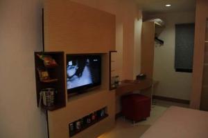 a room with a tv on a wall in a room at Antoni Hotel in Jakarta