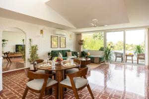 a living room with a table and chairs at El Volar by The Blue Kite - 2BHK, 5 Mins to Casino & 10 Mins to Candolim Beach with Big common Pool, Fully Equipped Kitchen, 24x7 Security, WiFi in Nerul
