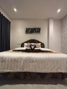 a bedroom with a large bed with white sheets at Rumah Ramah Ubud in Ubud +3 photos