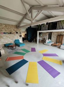 een kamer met een kleurrijke vloer met stoelen en tafels bij Le grand gîte du Causse in Cuq-Toulza