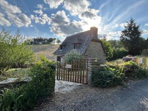 a small house with a wooden gate and a fence at Lacouty le paradis! in Junhac