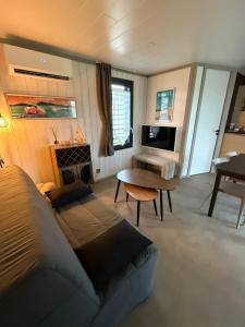 a living room with a bed and a table at Le Clos de Mizou "Dog Friendly" comme à la maison in Saubrigues