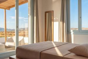 a bedroom with a bed and a window with a view at Kyma Paros Sea View Luxe Suite in Paros National Airport