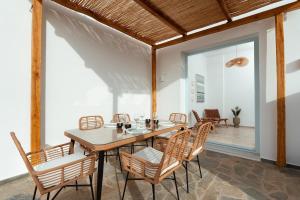 a dining room with a wooden table and chairs at Kyma Paros Sea View Luxe Suite in Paros National Airport