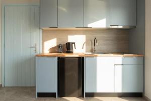 a kitchen with a counter with a sink and a coffee maker at Kyma Paros Sea View Luxe Suite in Paros National Airport +15 photos