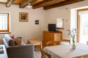 a living room with a table and a tv at Albergo Diffuso Ravascletto in Ravascletto