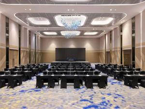 una sala conferenze con tavoli e schermo di proiezione di Novotel Samator Surabaya Timur a Surabaya Altre 88 foto