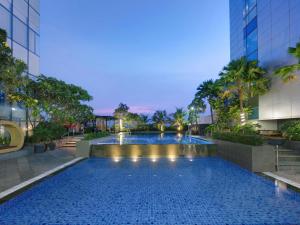 una piscina al centro di un edificio di Novotel Samator Surabaya Timur a Surabaya