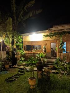 a garden at night with potted plants in the yard at Local Garden Homestay in Masbagik