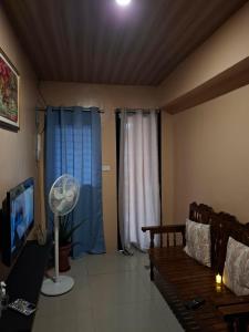 a living room with a couch and a fan at Queenbee's Place in Tagum +2 photos