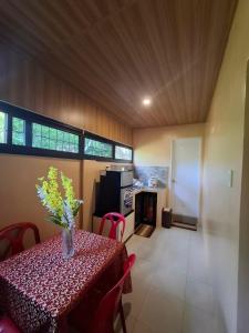 a dining room with a table with a vase of flowers on it at Queenbee's Place in Tagum