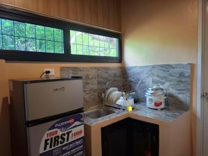 a small kitchen with a sink and a refrigerator at Queenbee's Place in Tagum