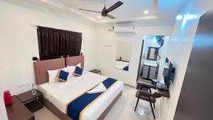a bedroom with a bed and a mirror and a television at Bakthapriya HILL VIEW RESIDENCY in Srikalahasti