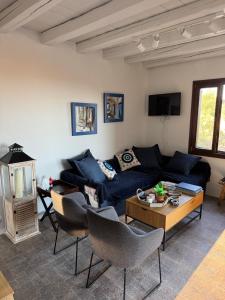 a living room with a blue couch and a table at Cycladic Serenity Sunset View Home in Otziás