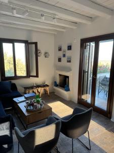 a living room with a couch and a table and chairs at Cycladic Serenity Sunset View Home in Otziás