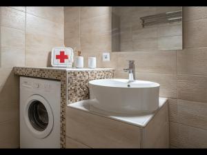 a bathroom with a sink and a washing machine at Hara Apartments in Chrysoupolis +24 photos