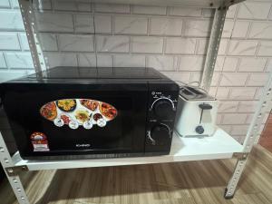 a microwave on a shelf with a plate of food on it at ff HILLTOP VIEW in Kampong Kundassan