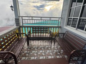 two benches on a balcony with a view of the ocean at ff HILLTOP VIEW in Kampong Kundassan