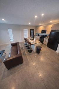 a large room with a long table and leather furniture at Cozy Greenwood Canopy in Des Moines