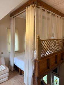 a bedroom with a canopy bed with curtains at Κτήμα Παππά Ρετιρέ in Livadeia