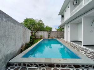 a swimming pool in the backyard of a house at Naungan Intaran Mandala in Sanur