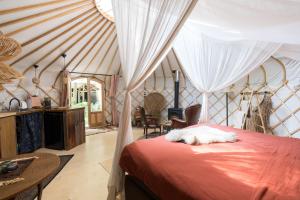 una camera da letto con un letto in una tenda di Unieke Yurt in het bos met jacuzzi en sauna a Erp