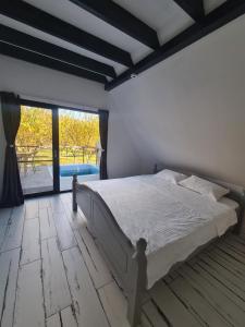 a bedroom with a large bed and a large window at The House in Corbi +18 photos