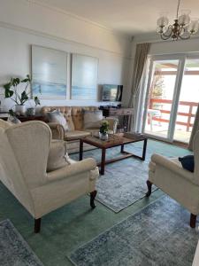 a living room with two chairs and a table at On the Sea in Cape Town