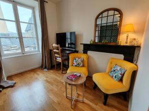 a living room with two chairs and a table at Petit appartement centre historique Laval in Laval
