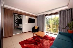 ein Wohnzimmer mit Tisch und großem Fenster in der Unterkunft Royal Torarica in Paramaribo