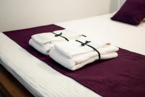 a pile of towels sitting on top of a bed at The Urban Stay in Galle