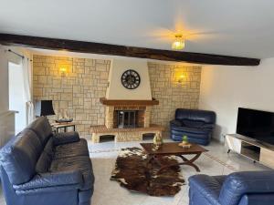 a living room with blue couches and a fireplace at Gîte Baytso in Auge