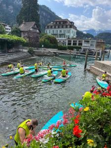 a group of people on kayaks in the water at BnB Villa Kapellmatt - Seezugang, Bio-Frühstück, SUP am Rigi in Vitznau