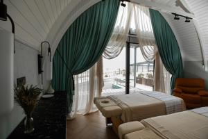 een slaapkamer met groene gordijnen, een bed en een balkon bij Caspi Mayr in Baku