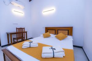 a bedroom with a bed with towels and a chair at The Urban Stay in Galle +23 photos