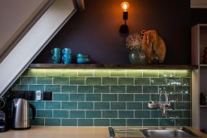 a kitchen with green subway tiles and a sink at Complete studio de Stopplaats dichtbij Hoorn en Alkmaar in Zuidermeer +36 photos