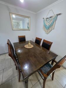 a dining room table with chairs and a mirror at Comfort, Safety, and Connectivity in Chillán