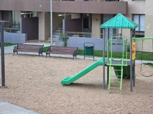 a playground with a slide and two benches at Comfort, Safety, and Connectivity in Chillán