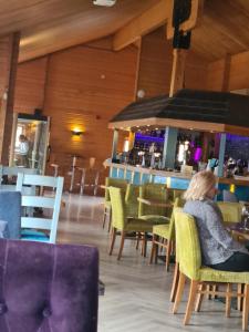 Una donna seduta su una sedia al bar di The Seaflower - With Lake Views a Millom