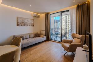 a living room with a couch and a large window at Belgrade Waterfront Residences - Beograd na vodi in Belgrade