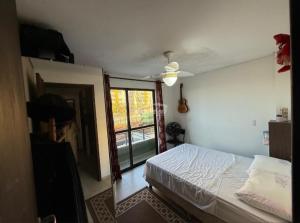 a bedroom with a bed and a ceiling fan at Condomínio Morada do sol in Barra Velha