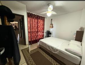 a bedroom with a white bed and a mirror at Condomínio Morada do sol in Barra Velha