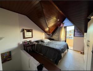 a bedroom with a large bed in a attic at Condomínio Morada do sol in Barra Velha