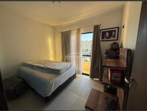 a bedroom with a bed and a large window at Condomínio Morada do sol in Barra Velha