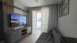 een woonkamer met een bank en een flatscreen-tv bij Sea View Apartment in Aracaju in Aracaju