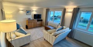 a living room with two chairs and a television at Oaktree Cottage, overlooking Loch Fyne in Cairndow