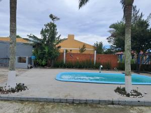a swimming pool in a yard with palm trees at Oásis Xangri-lá in Xangri-lá