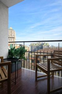 a balcony with benches and a view of a city at Corso Italia Rooms in Milan