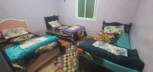 a room with three beds and a window at Gîte tazekka in Taza