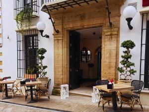 een terras met tafels en stoelen voor een gebouw bij VILLTAK La Maison - Adults Recommended Only in Marbella